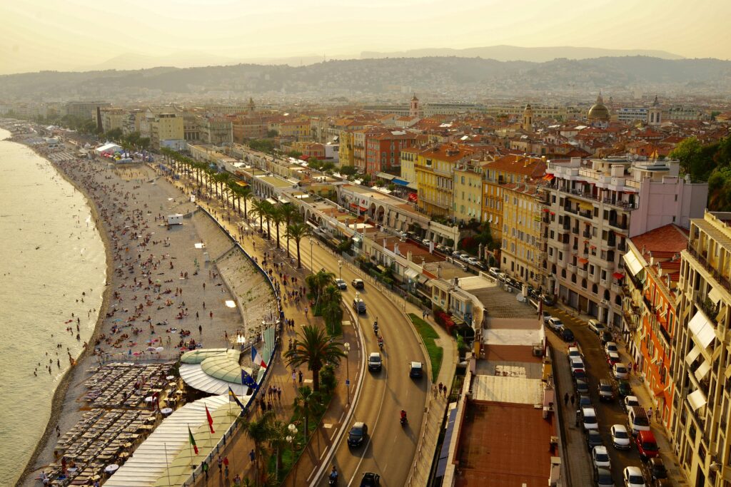 Aerial view of Promenade des Anglais in Nice capturing vibrant urban and beach life on a sunny day.
