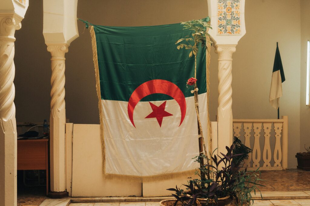 Interior view showcasing the Algerian flag hanging amid classic columns in Alger Centre.